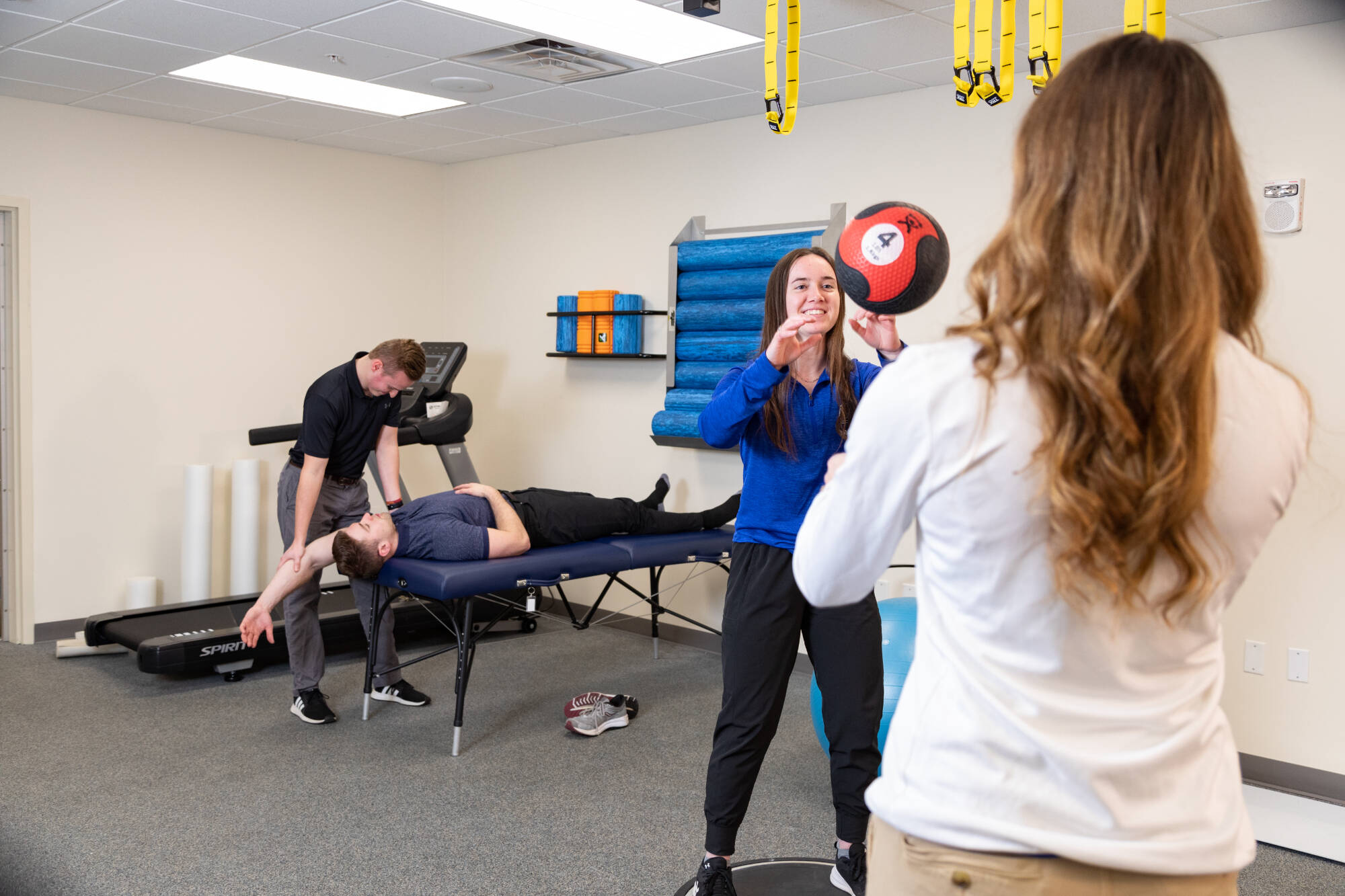 Students and faculty practice training exercises in a gym setting